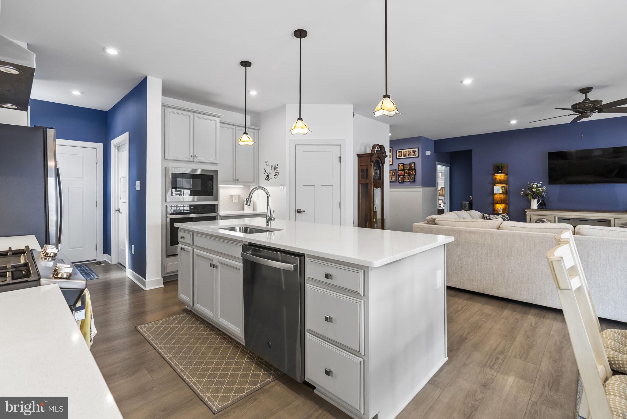 112 Frame Drive Coatesville, PA 19320 - Photo 14 of 55 a kitchen with stainless steel appliances kitchen island granite countertop a sink a stove a refrigerator a kitchen island with wooden floor and cabinets