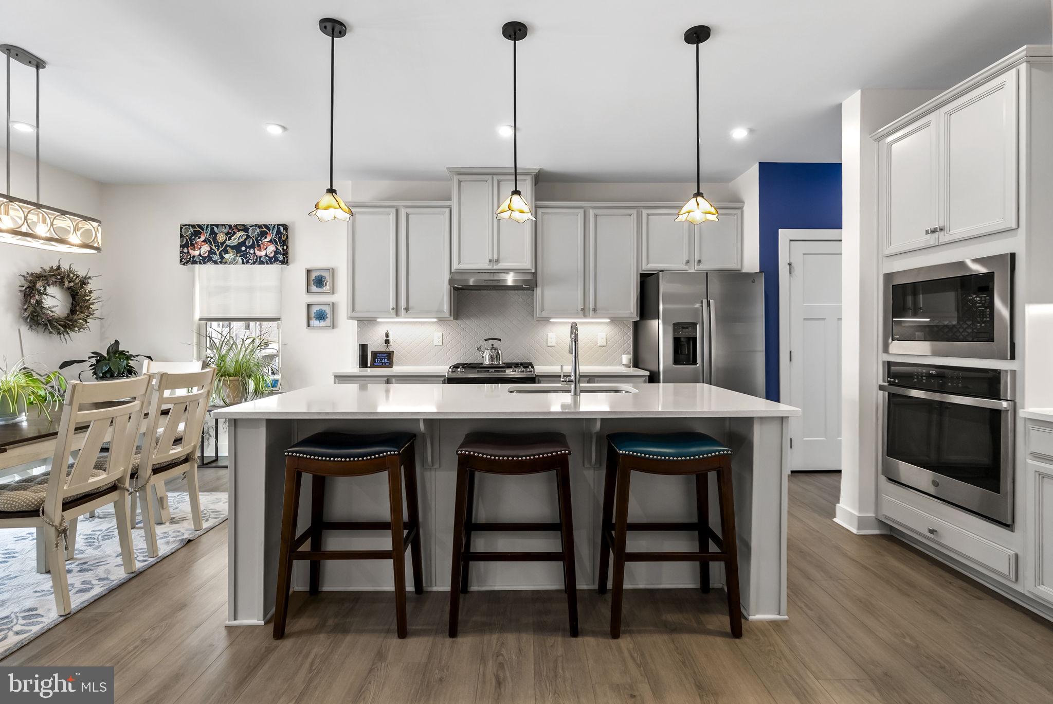 112 Frame Drive Coatesville, PA 19320 - Photo 15 of 55 a kitchen with stainless steel appliances granite countertop a stove a refrigerator a oven a sink with a dining table and chairs