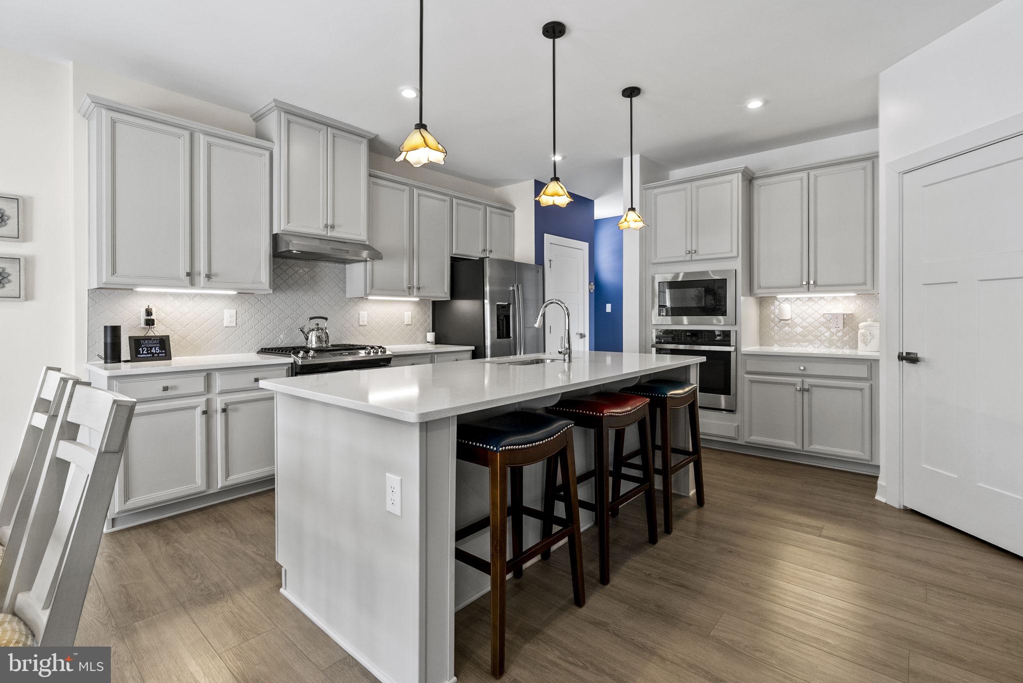 112 Frame Drive Coatesville, PA 19320 - Photo 16 of 55 a kitchen with stainless steel appliances granite countertop a stove a sink a refrigerator a microwave oven a stove and white cabinets with wooden floor