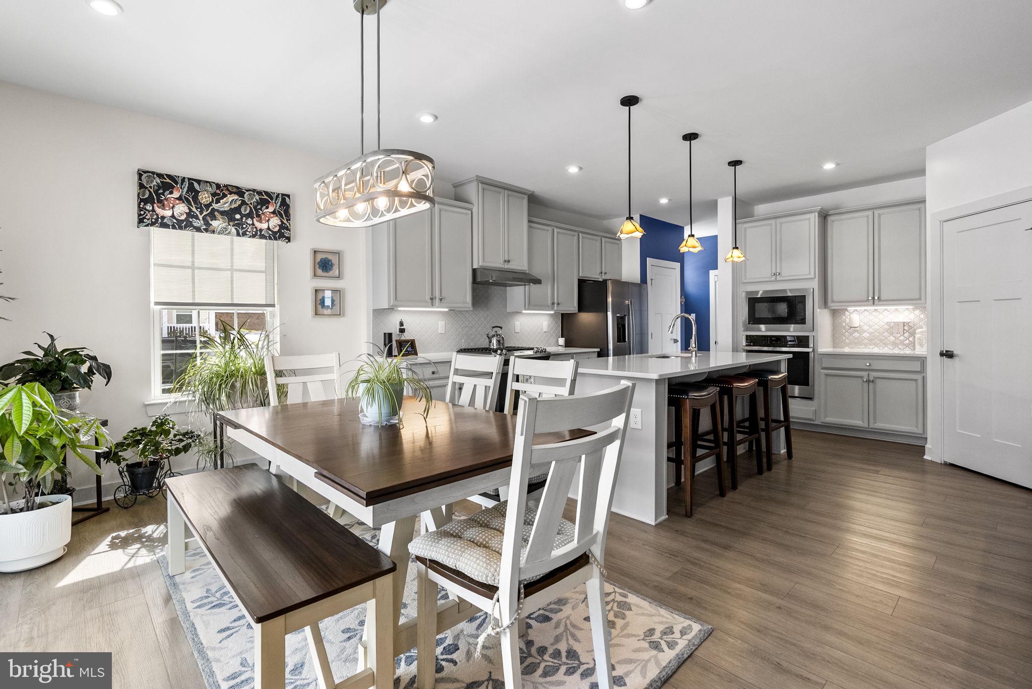 112 Frame Drive Coatesville, PA 19320 - Photo 20 of 55 a kitchen with stainless steel appliances kitchen island granite countertop a stove a refrigerator a oven a sink a dining table and chairs with wooden floor