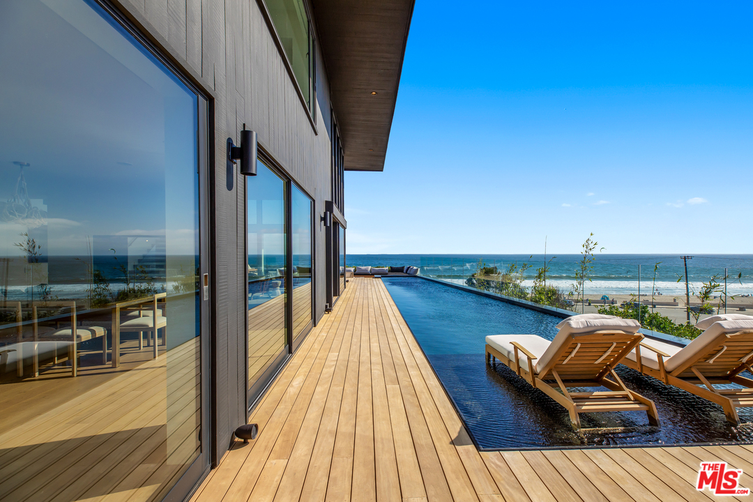 6463 Surfside Way Malibu, CA 90265 - Photo 21 of 31 a balcony with wooden floor and outdoor seating