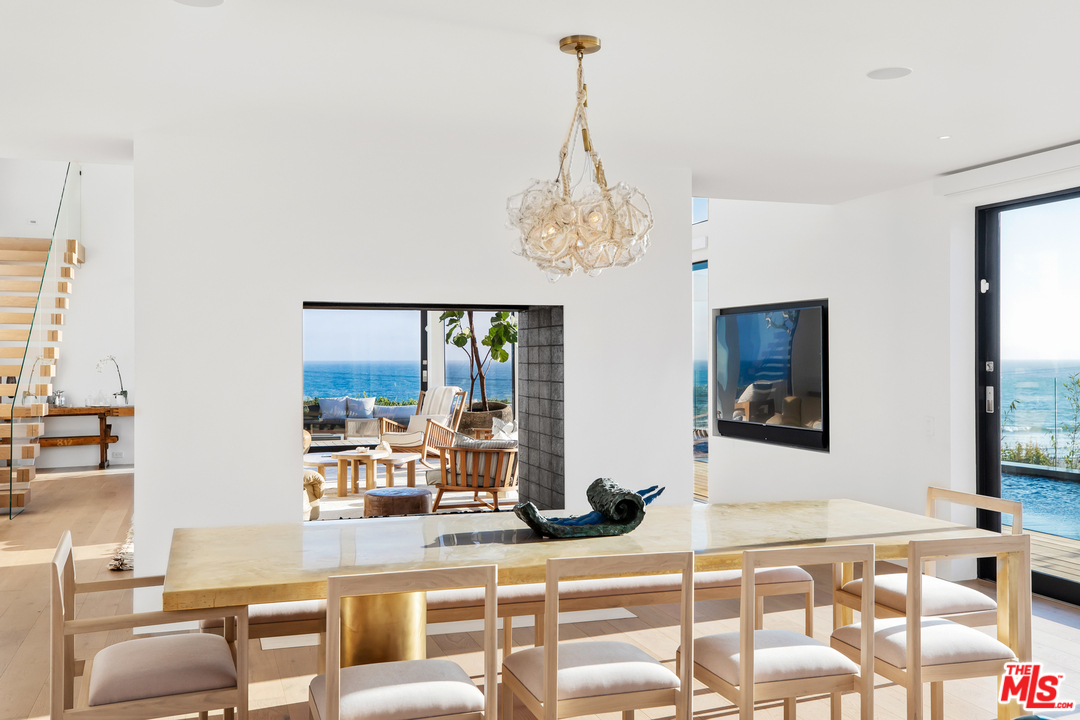 6463 Surfside Way Malibu, CA 90265 - Photo 10 of 31 a dining room with furniture and a chandelier