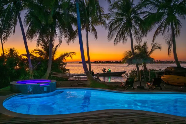 a view of a swimming pool with lawn chairs under an umbrella