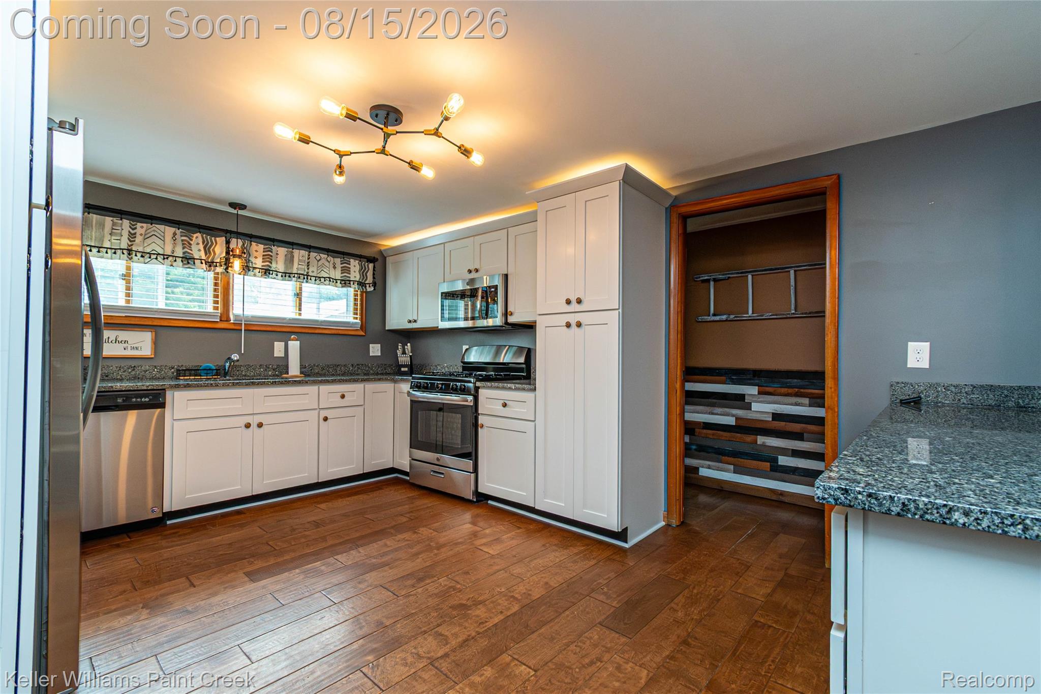 330 East Washington Street Romeo, MI 48065 - Photo 33 of 68 Kitchen featuring wood-finish flooring, white cabinetry, stainless steel appliances, and dark speckled countertops