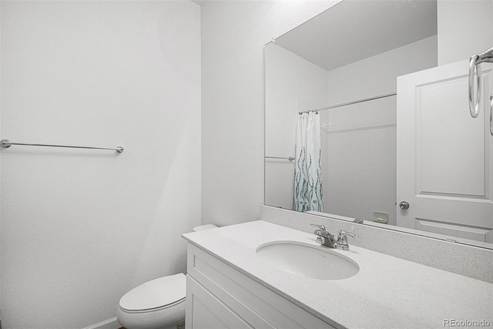 18235 Caffey Drive Parker, CO 80134 - Photo 17 of 38 a bathroom with a granite countertop sink toilet and a mirror