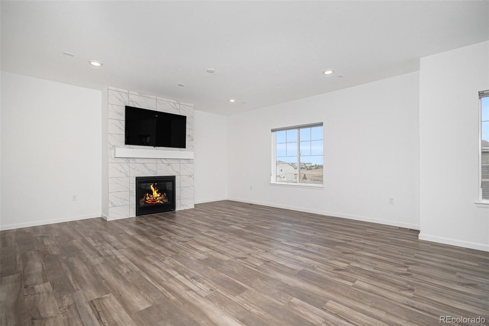 18235 Caffey Drive Parker, CO 80134 - Photo 4 of 38 a view of an empty room with wooden floor and a fireplace