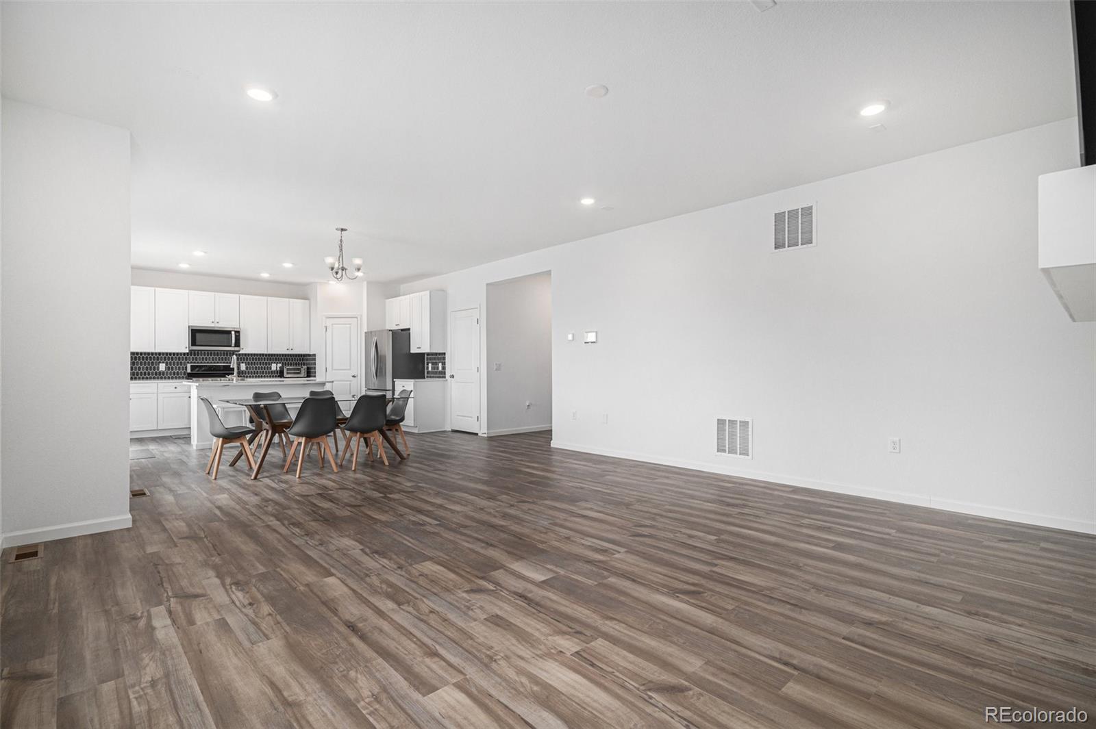 18235 Caffey Drive Parker, CO 80134 - Photo 7 of 38 a view of a kitchen with dining room and wooden floor