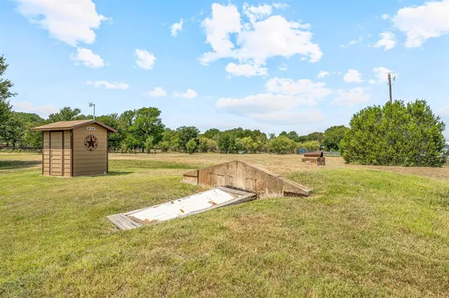 an aerial view of residential houses with outdoor space and trees