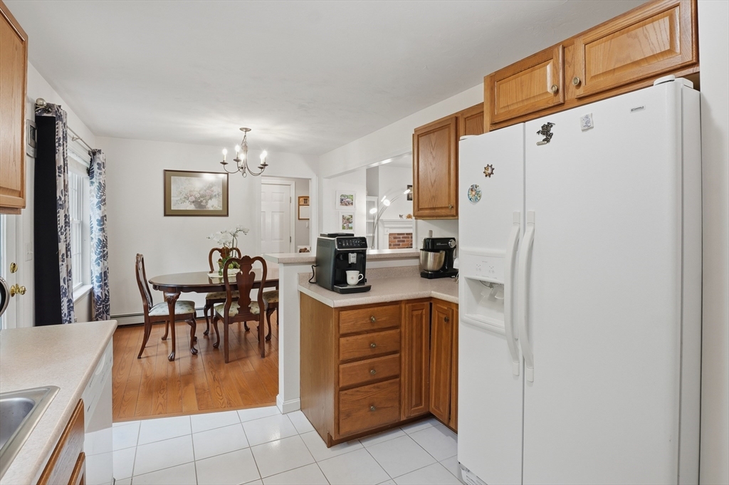 186 Common Street Groton, MA 01450 - Photo 10 of 28 a kitchen with a refrigerator a dining table and chairs