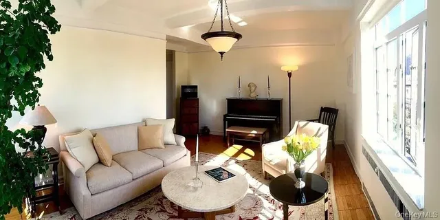 a living room with furniture a flat screen tv and a window