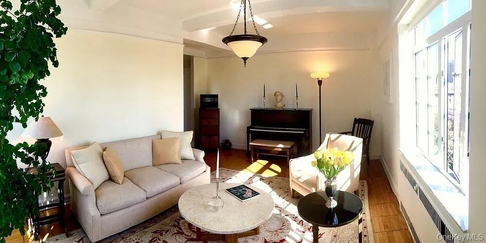 a living room with furniture a flat screen tv and a window