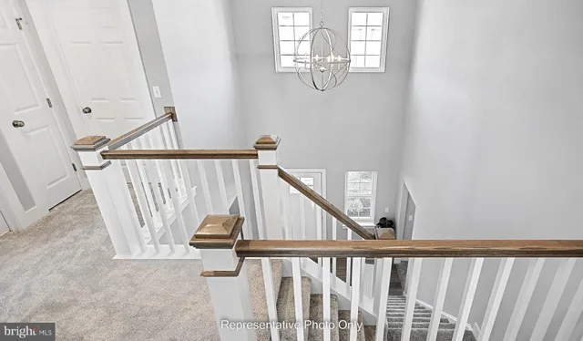 a view of staircase with railing and white walls