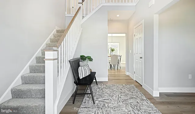 a view of a hallway with wooden floor and stairs