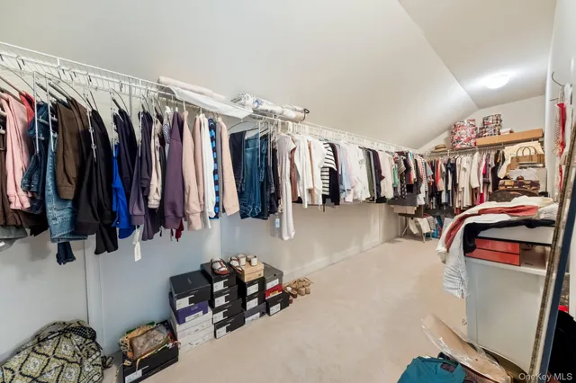 a view of walk in closet with clothes and shoes