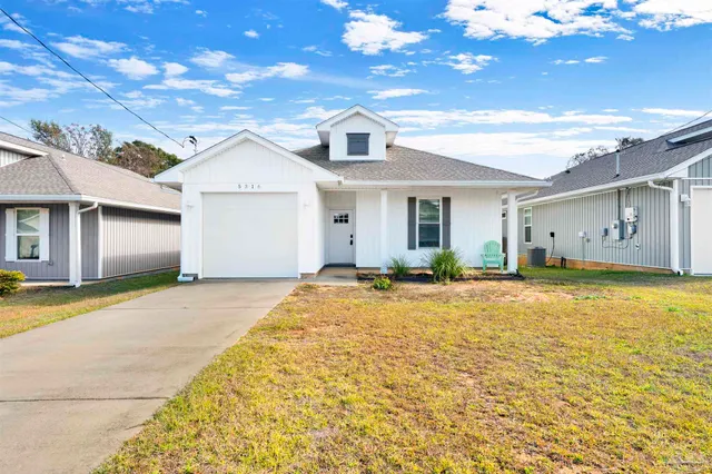 a view of a white house with a yard and garage