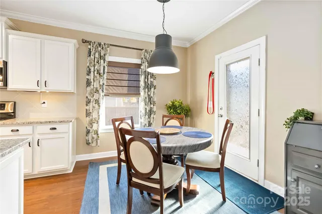 a dining room with furniture a chandelier and wooden floor