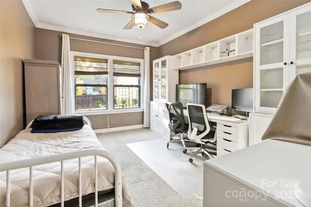 a bedroom with a bed a table and chair with a large window