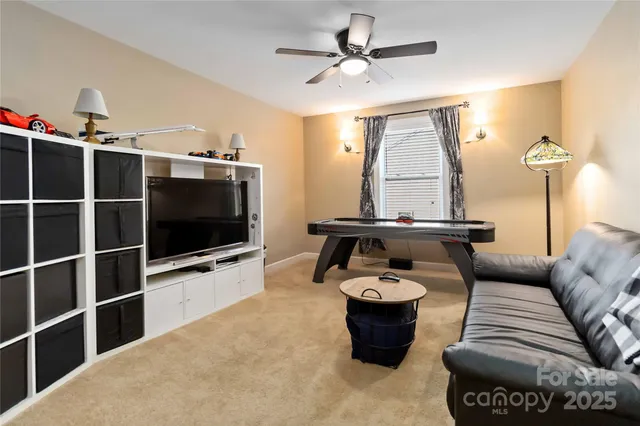 a living room with furniture a flat screen tv and a large window