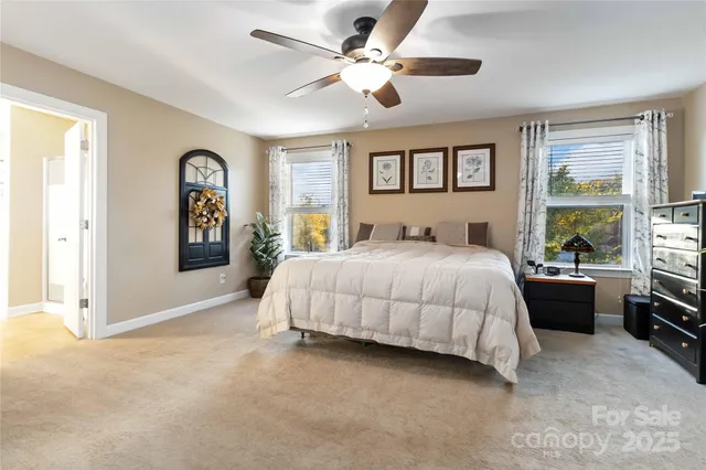 a bedroom with a large bed and a chandelier