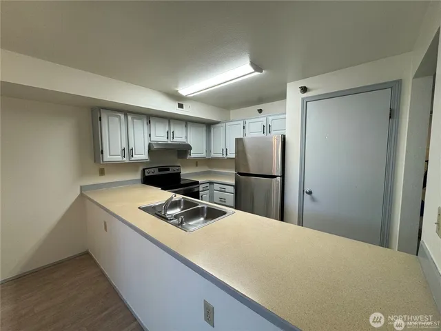 a kitchen with refrigerator cabinets and a sink