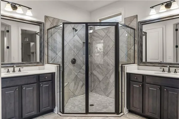 a bathroom with a double vanity sink mirror and shower