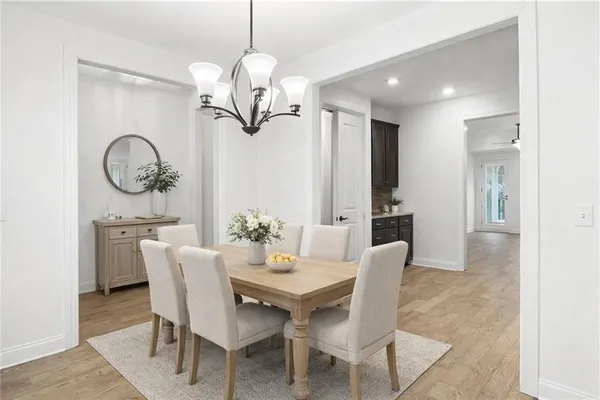 an empty room with wooden floor ceiling fan and windows