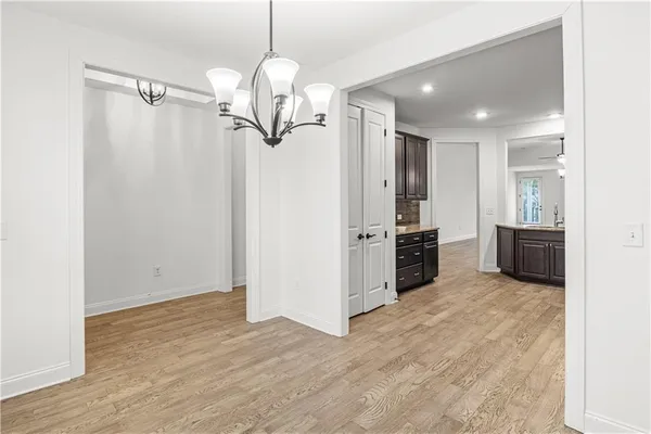 a view of a kitchen with stainless steel appliances a refrigerator and a wooden floor