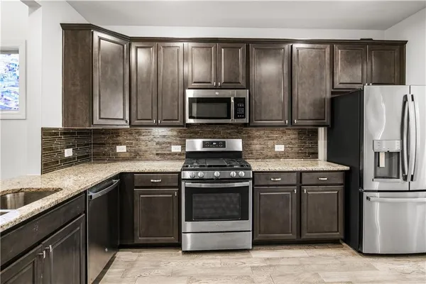 a kitchen with granite countertop stainless steel appliances and wooden cabinets