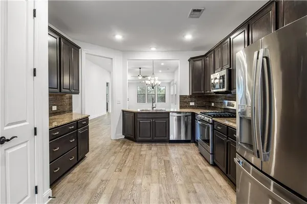 a kitchen with stainless steel appliances a refrigerator and a stove top oven