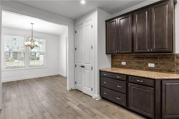 a view of kitchen with granite countertop wooden cabinets stainless steel appliances and a window