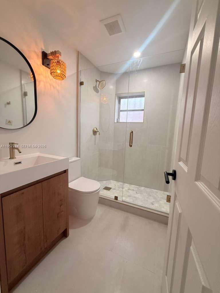 525 Southwest 22nd Avenue, Unit B Miami, FL 33135 - Photo 12 of 13 a bathroom with a sink a toilet and a mirror