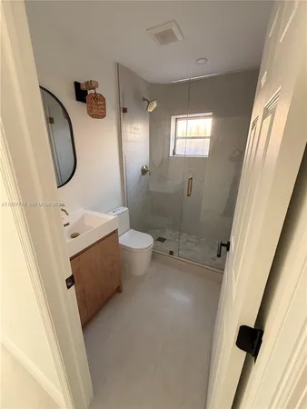 a bathroom with a sink a toilet and shower