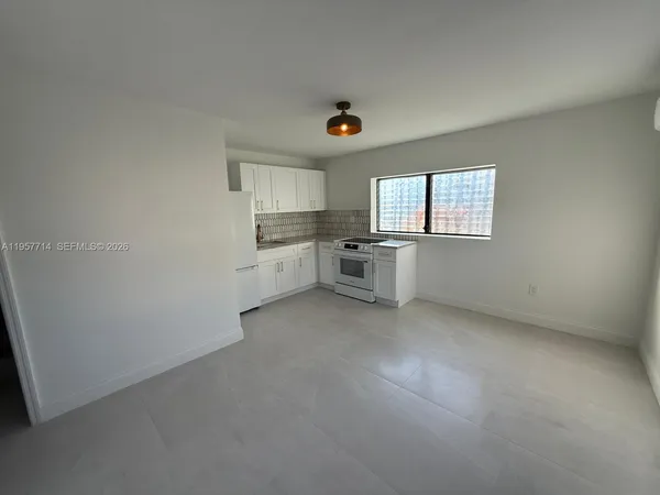 an empty room with windows & cabinet windows