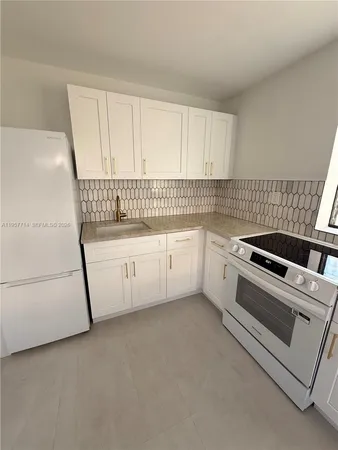 a kitchen with white cabinets and white appliances