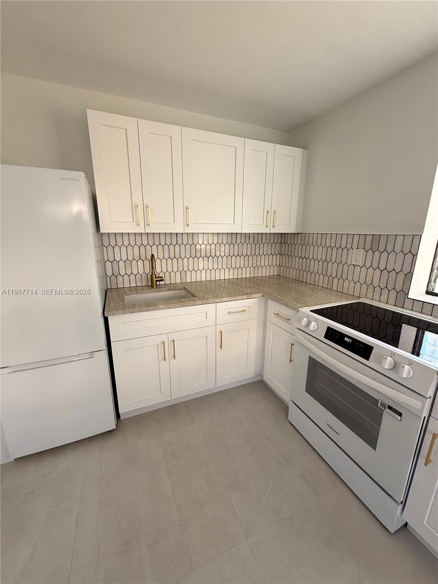 525 Southwest 22nd Avenue, Unit B Miami, FL 33135 - Photo 4 of 13 a kitchen with white cabinets and white appliances
