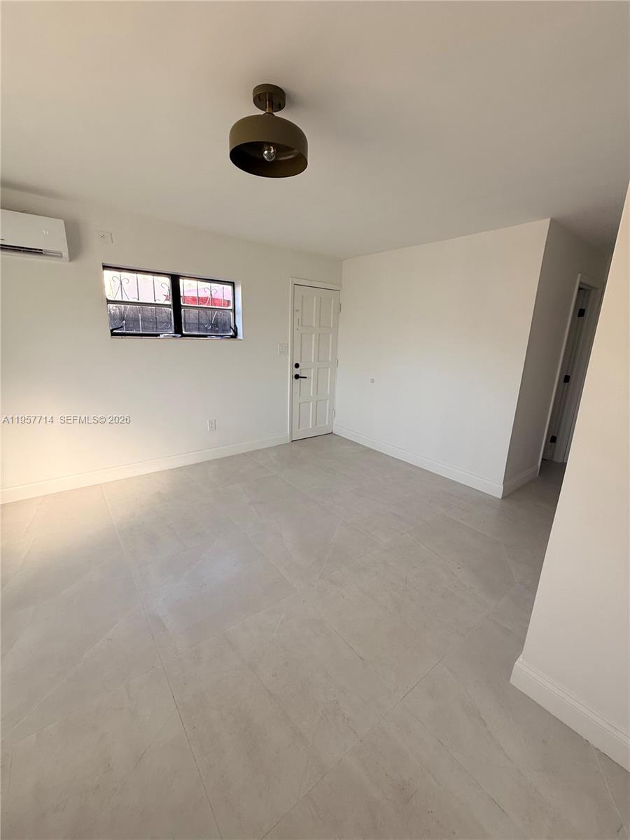 525 Southwest 22nd Avenue, Unit B Miami, FL 33135 - Photo 5 of 13 an empty room with a ceiling fan and window
