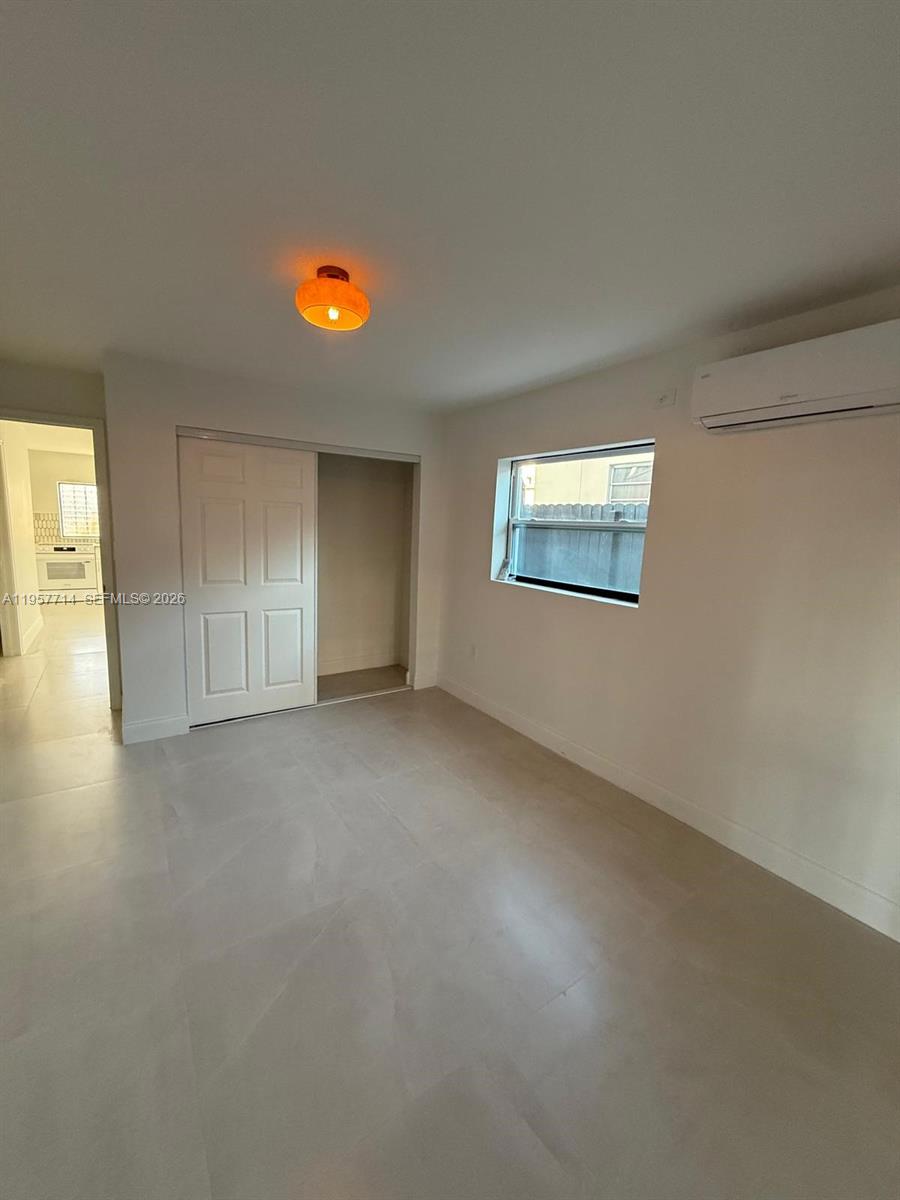 525 Southwest 22nd Avenue, Unit B Miami, FL 33135 - Photo 10 of 13 an empty room with windows and painted walls