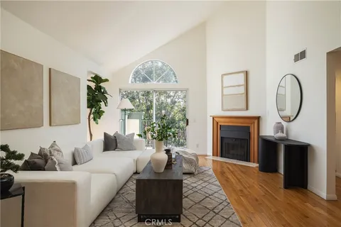 a living room with furniture a fireplace and a large window