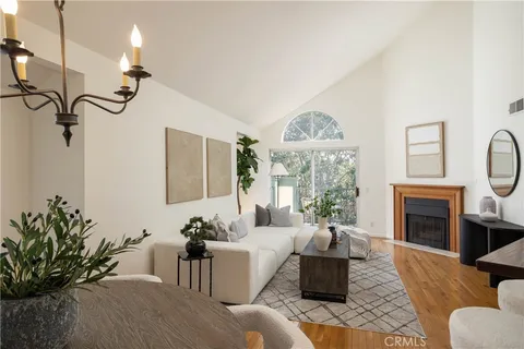 a living room with furniture a fireplace and a potted plant