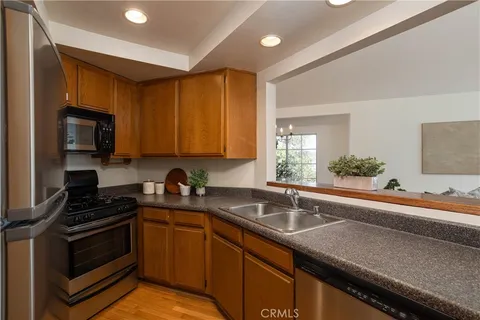 a kitchen with sink a microwave and cabinets