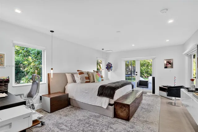a bedroom with a bed and large window