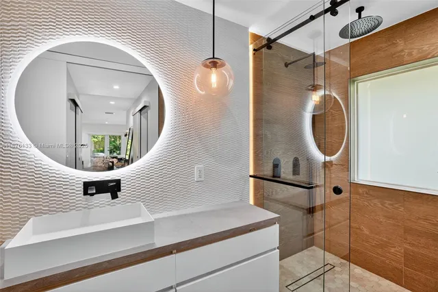 a bathroom with a sink mirror and vanity