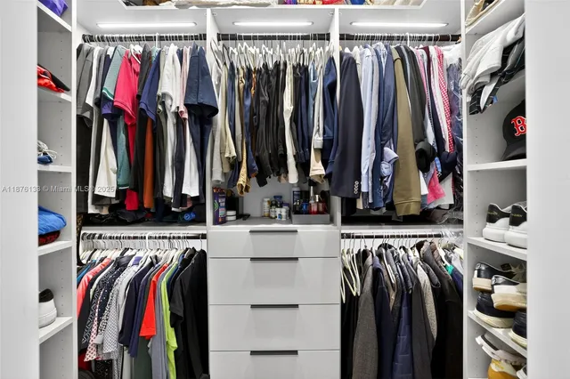 a view of walk in closet with clothes