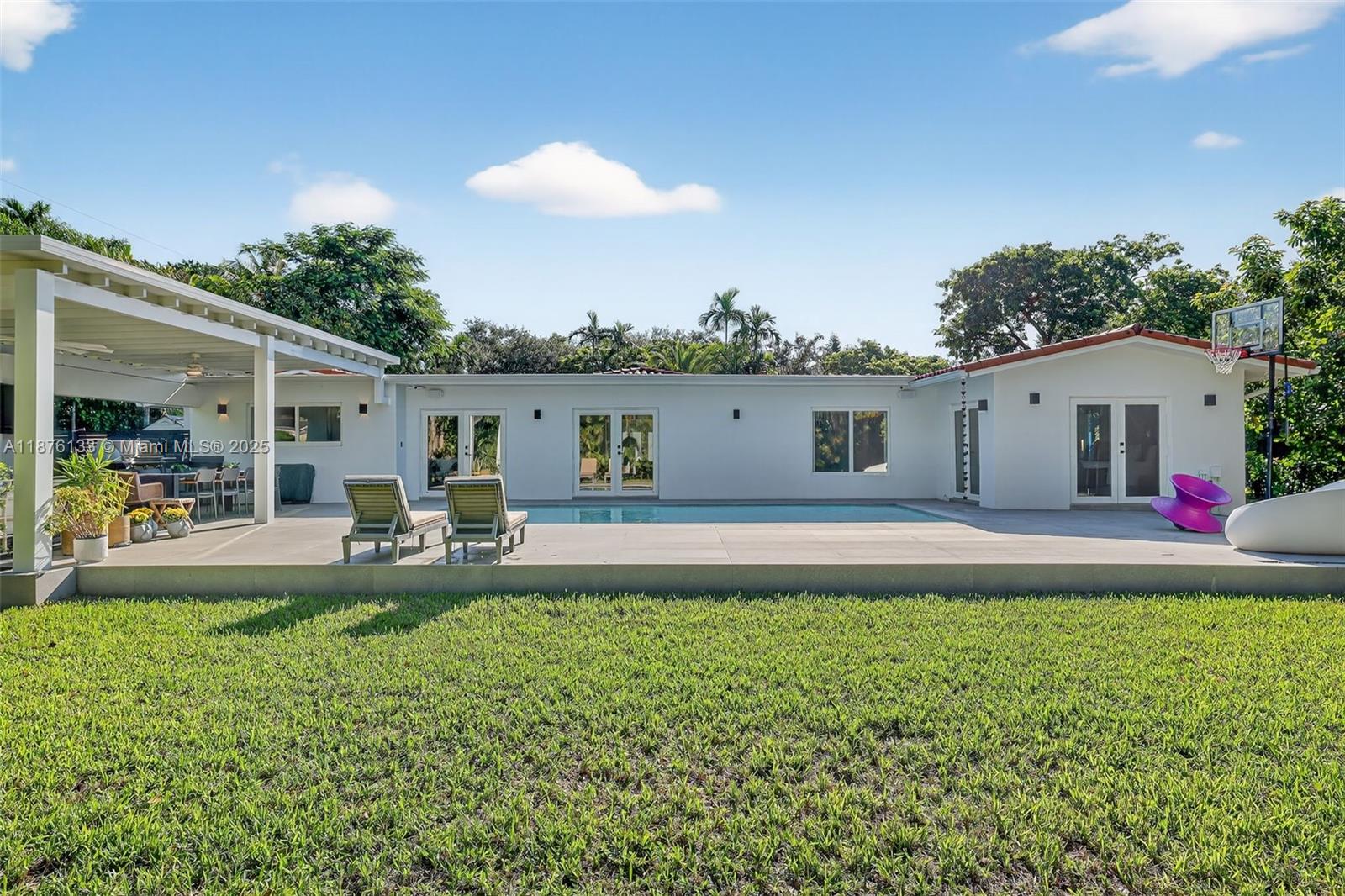 10740 Southwest 73rd Court Pinecrest, FL 33156 - Photo 29 of 37 a front view of a house with a patio and a fire pit