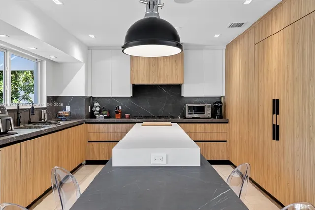 a kitchen with granite countertop a stove a sink dishwasher and a refrigerator with wooden floor