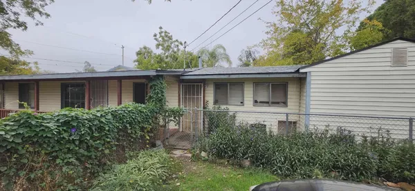 a front view of house with yard and trees around