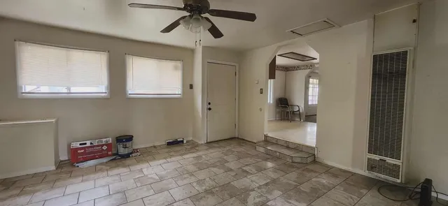 a view of a livingroom with a chandelier fan and windows