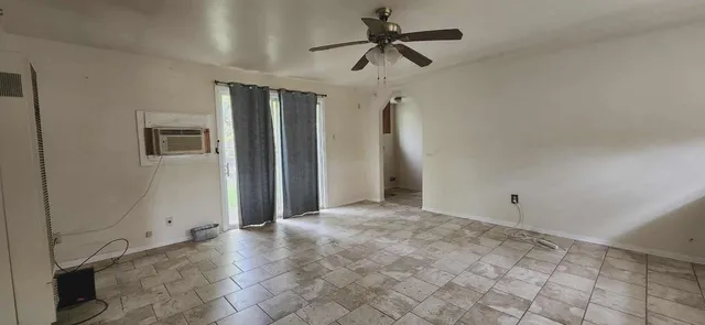 a view of a livingroom with a ceiling fan and window