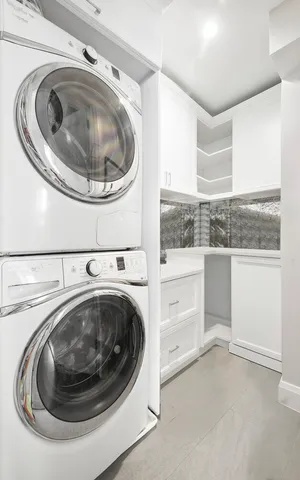 a view of an empty room with kitchen cabinet and a window