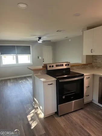 a kitchen with a stove and a white cabinets